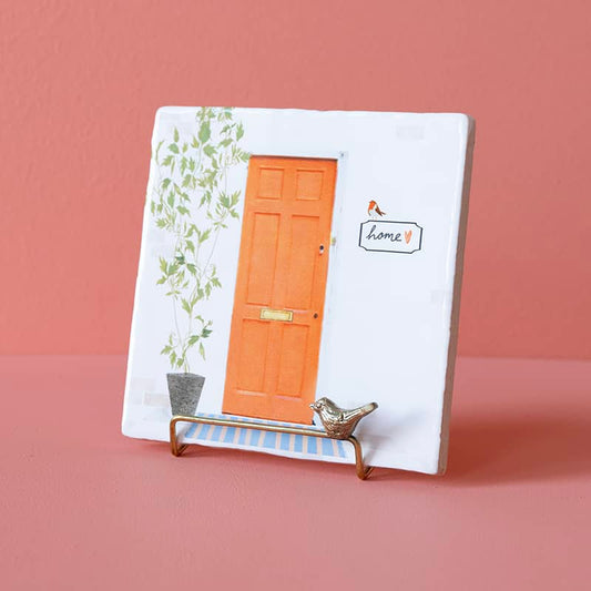 Gouden tegelhouder met vogelmotief voor roze achtergrond gepresenteerd