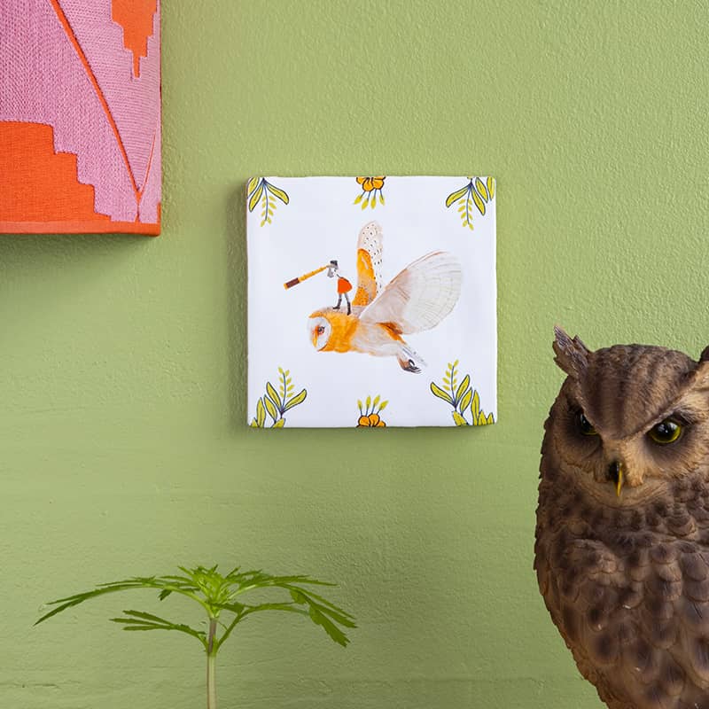 Tegeltje uilenvlucht aan groene muur met decoratieve rand