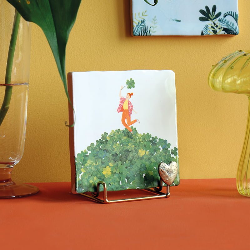 Tegeltje met vrouw op berg klavertjes, op standaard