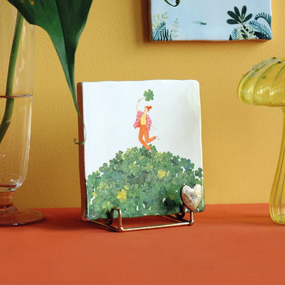 Tegeltje met vrouw op berg klavertjes, op standaard