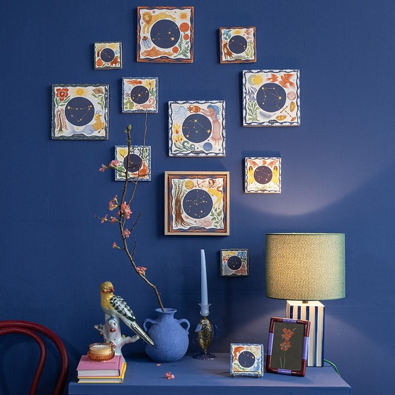 Geboortetegeltjes astrologie, kleurig gerangschikt tegen blauwe wand