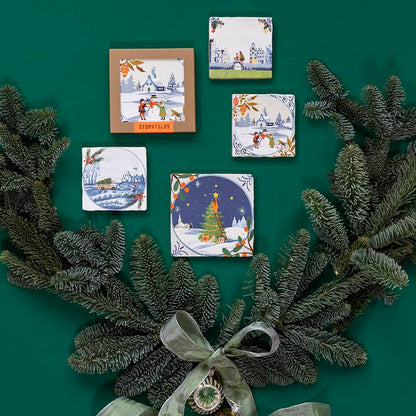 Kersttegeltje wintertaferelen omringd door groene dennentakken en strik