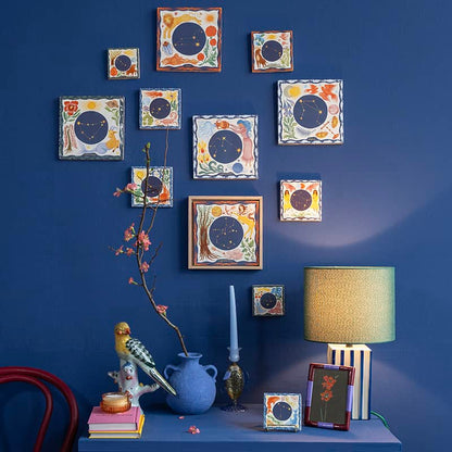 Geboortetegeltjes sterrenbeelden kleurrijk op blauwe muur gepresenteerd