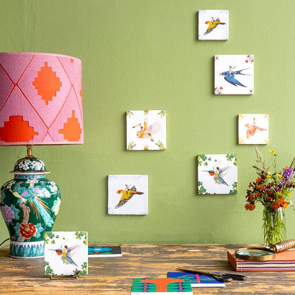Tegeltje vogels wanddecoratie tegen groene muur met lampen