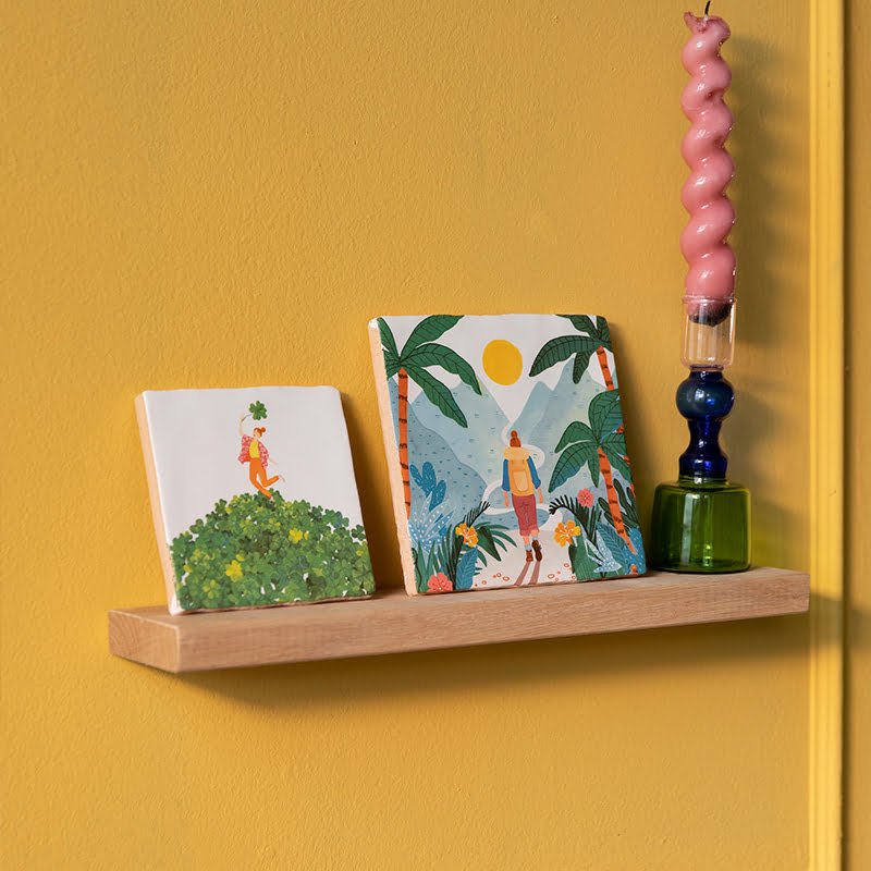 Tegeltje met persoon op heuvel, geplaatst op houten plank