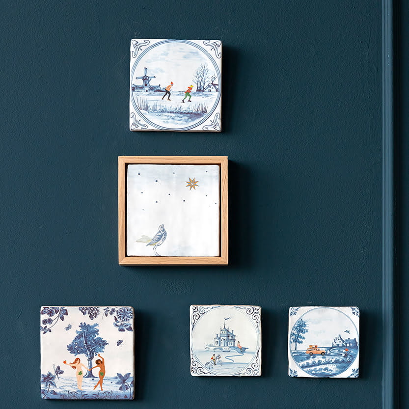 Tegelhouders in een donkerblauwe muur, vijftal decoratieve tegels