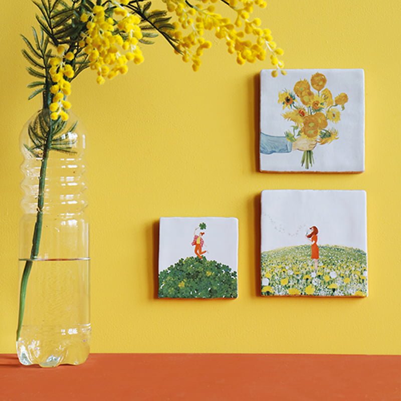 Tegeltjes met bloemenmotieven tegen een gele muur gepresenteerd