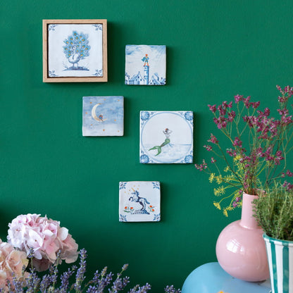 Geboortetegels verschillende illustraties aan groene muur met bloemen