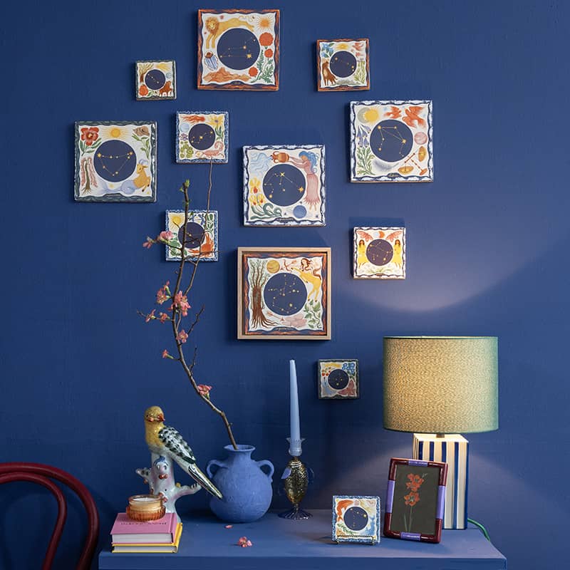 Geboortetegels met sterrenbeeldmotieven aan een blauwe muur