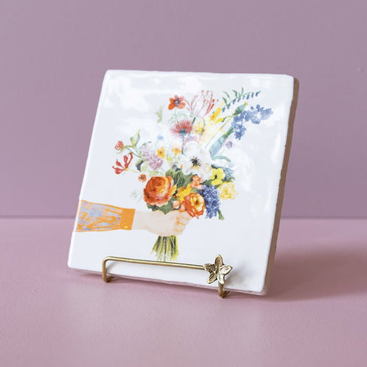 Gouden tegelhouder met bloemmotief op roze achtergrond