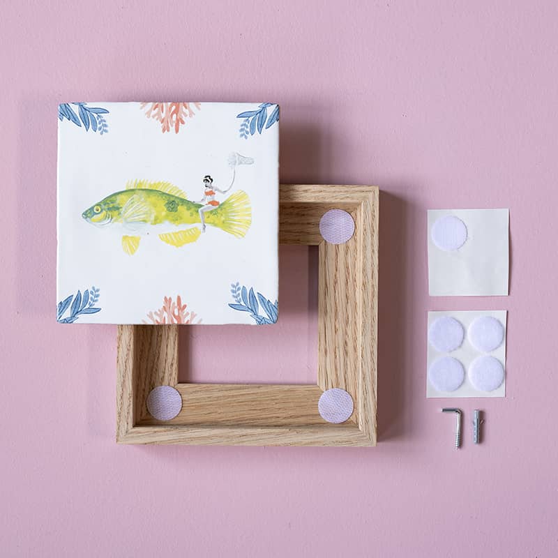 Tegelhouder en tegel op roze ondergrond met bevestigingsmateriaal